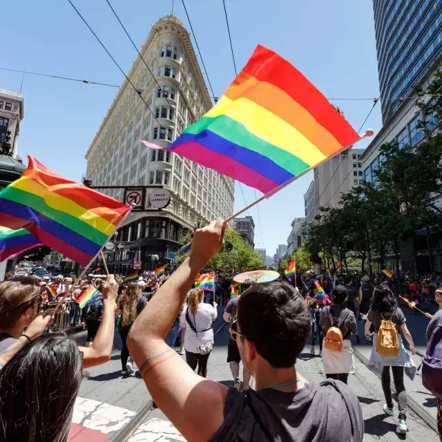 La gente que camina en el desfile del Orgullo de San Francisco ondea banderas del arco iris.