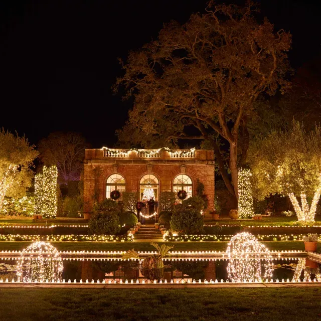 La gran casa señorial está iluminada por luces por la noche